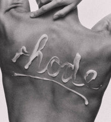 rhode written on model's back with barrier butter