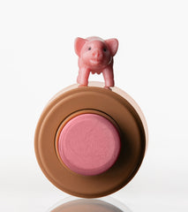 pocket blush piggy, a small pink pig toy on top of it