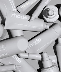large pile of rhode products, including: peptide glazing fluid, barrier restore cream & peptide lip treament