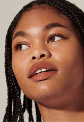 model with glossy lips, wearing toast lip tint