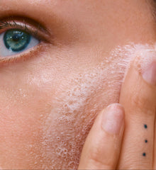 close up of a model's face with bubbles on her face