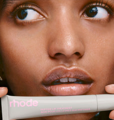 model holding peptide lip treatment in rhode vanilla