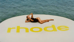 HB lying down on a giant float with rhode logo